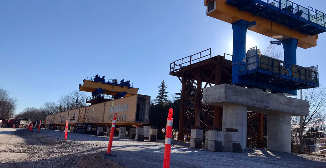 Upon arriving near the railroad right-of-way, the transporter began a complex manoeuvre to bring each of the 87-metre-long beams onto the REM construction site.